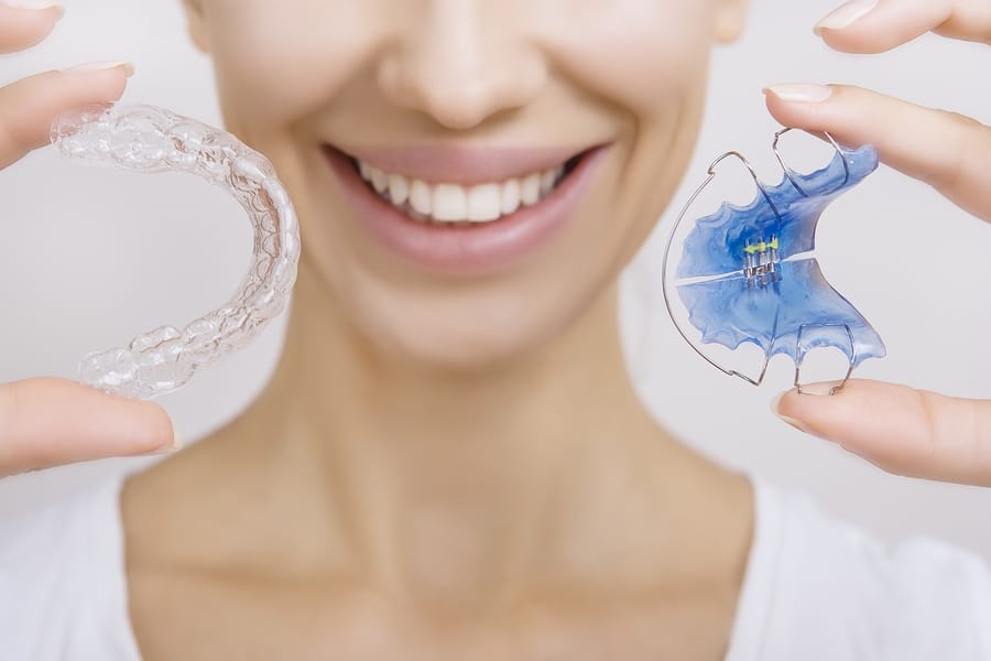 bigstock-Smiling-Girl-Holding-Retainer-95279225
